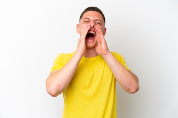 Young brazilian man isolated on white background shouting and announcing something