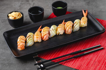 Sushi set of various products on a black stone plate