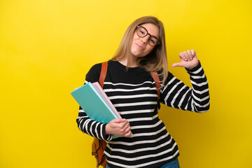 Young student woman isolated on yellow background background proud and self-satisfied