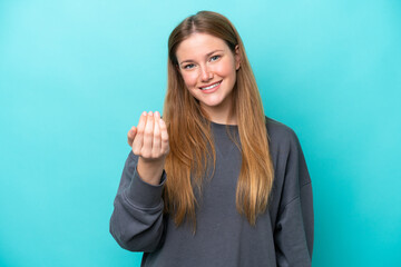 Young caucasian woman isolated on blue background inviting to come with hand. Happy that you came