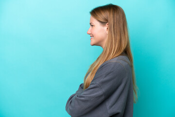 Fototapeta premium Young caucasian woman isolated on blue background in lateral position