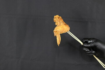 Holding Crunchy Fried Chicken Wing - Black Background  Food Stcok Images