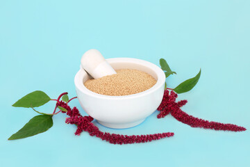 Amaranth dried grain in a mortar with amaranthus plant in flower. Health food gluten free, high in...