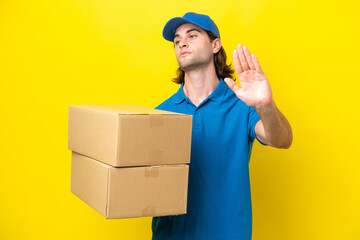 Fototapeta na wymiar Delivery handsome man isolated on yellow background making stop gesture and disappointed