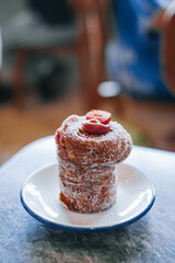 Close-up photo of a traditional easter cake called Cruffin or Kraffin on a small white plate with bokeh