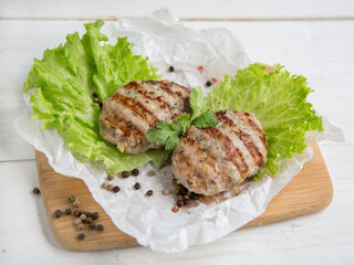 Delicious turkey poultry cutlets. dietary product. Two cutlets lie on a wooden board with a lettuce leaf.