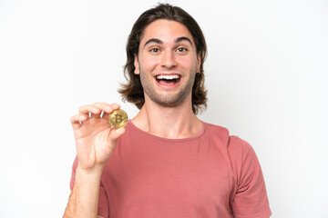 Young handsome man holding a Bitcoin isolated on white background with surprise and shocked facial expression