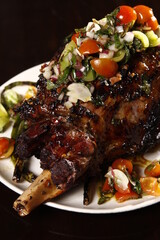 Whole roasted lamb leg with mint sauce and vegetables