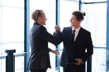 businessman shaking hands with friends and having fun in the office