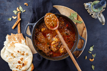 Traditional spicy Indian chicken Madras curry Rogan Josh with drumsticks, wings and garlic chapati...