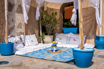 Arabic majlis, traditional Arabic seating area on the floor with white decorated cushions, blue rug...