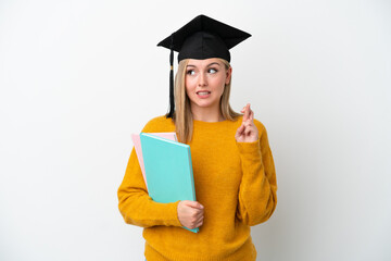 Young student caucasian woman isolated on white background with fingers crossing and wishing the best