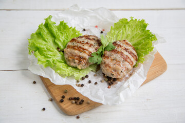 Delicious turkey poultry cutlets. dietary product. Two cutlets lie on a wooden board with a lettuce leaf.