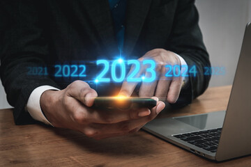 Trend of 2023. people business investor using mobile phone with virtual 2023 year diagram, business trend, change from 2022 to 2023, strategy, investment, business planning and happy new year concept