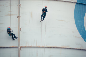 Male two worker rope access  inspection of thickness storage tank