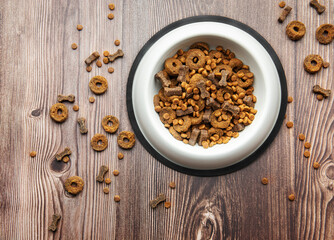 A bowl of dog food on a wooden floor.