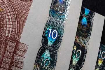 A macro image of the holographic foil features on a Euro banknote, showcasing the security measures in place to prevent counterfeiting - 561239938