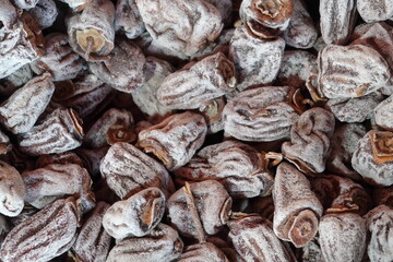 Dried persimmon fruits are sold by the herbalist. A scattering of dried persimmons, oriental sweets.