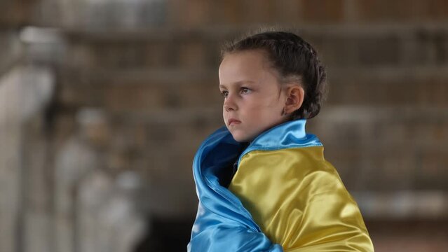 Portrait of a sad child with a Ukrainian flag. Migrant children from Ukraine. Russia's aggression 
