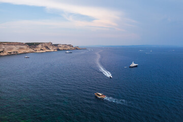 Motor boats goes near rocky coasts of Bonifacio. Landscape of Corsica