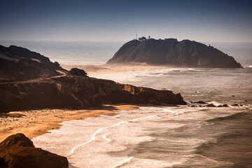 Pacific ocean waves crash the rocky beach coast at Point Sur State historic park in California by the Cabrillo highway US 1.