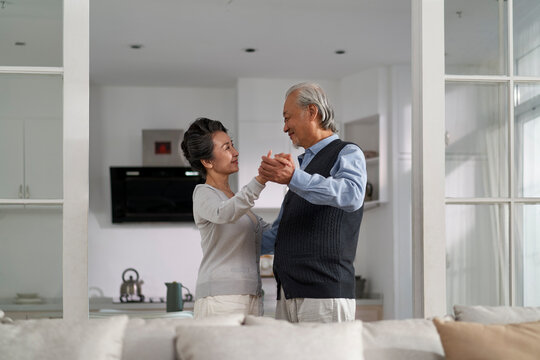 Loving Asian Old Couple Dancing At Home