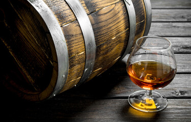 Cognac in a glass with a barrel.