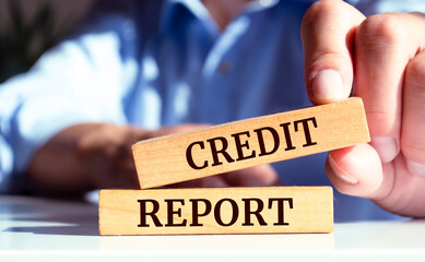 Closeup on businessman holding a wooden block with "Credit report", Business concept