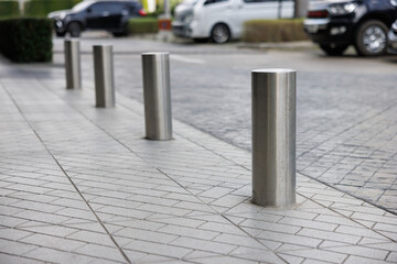 stainless steel bollards on footpath near car park lot. metal barrier pillars.