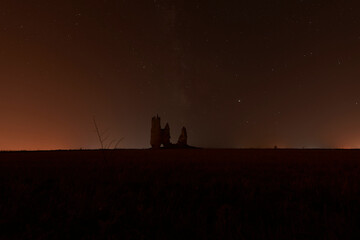 Naklejka na ściany i meble Caudilla castle in ruins at night with the Milky Way. Spain