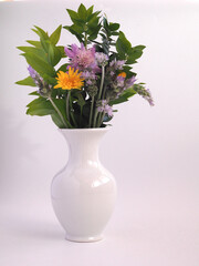 Wildflowers in a white ceramic vase. Cottage style