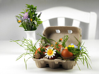 Easter eggs with flowers decorated in hipster style in a cardboard egg box.