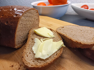 Rustikales Brot mit Butter auf einem Schneidbrett in der Küche