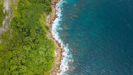 Beautiful aerial top view to coastline near Saren Cliff Point. Clear water and rocks. Nusa Penida, Indonesia.