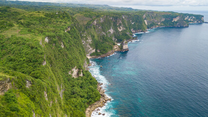 Obraz na płótnie Canvas Beautiful coastline aerial view from Saren Cliff Point. Clear water and rocks with cloudy sky. Nusa Penida, Indonesia.