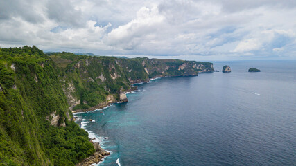 Fototapeta na wymiar Beautiful coastline aerial view from Saren Cliff Point. Clear water and rocks with cloudy sky. Nusa Penida, Indonesia.