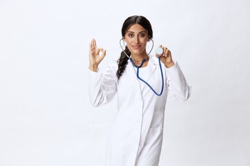 Woman doctor with stethoscope in hand in medical gown on white nurse background, consequences of...