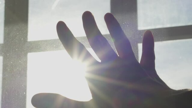 Human hand on background of sun. Backlight silhouette sunlight at sunset sunrise. The concept of love, dream, religion, faith in god, prayer, meditation. Christian Muslim raises his hands to the sky.