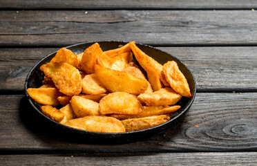 Baked potato slices in a frying pan.