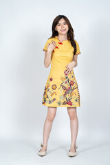 A beautiful asian woman doing a pose while wearing simple yellow chinese dress
