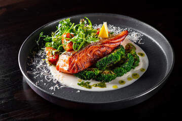 Fried salmon with creamy sauce, broccoli and salad