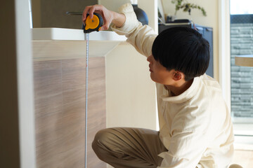 室内の高さを測る男性