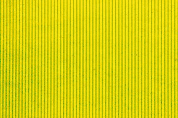 Obraz premium Abstract paper yellow geometric symmetrical texture striped surface vertical lines background. Structure design cardboard shape backdrop. Holiday spring decoration interior concept. Flatlay, close-up