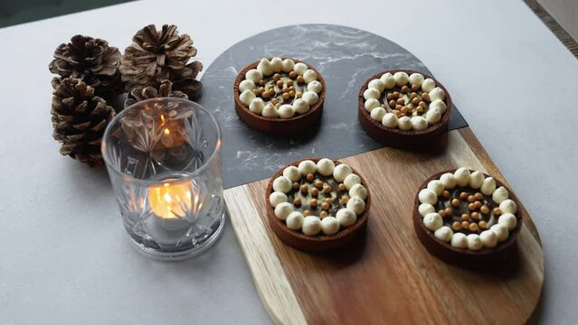 Top View Of Four Beautiful Small Chocolate Tarts Decorated With Small Meringues And Pearls. Artistic Bakery Goods. High Quality 4k Footage