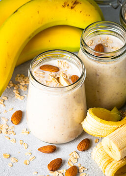 Almond banana smoothie with oat flakes in glass. Close up image.