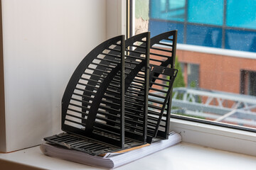 Vertical paper trays or document holders empty on windowsill in office