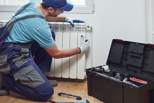 Central heating mechanic and handyman fixing home radiator, gas crisis and seasonal issues.