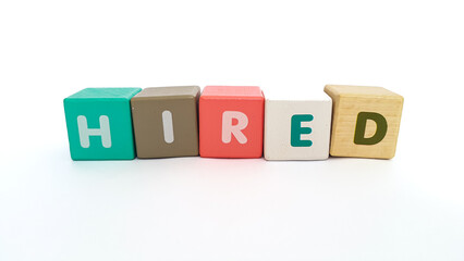 Word hired on colorful wooden cubes. Word hired on colorful wooden blocks on white background. Hired symbol.