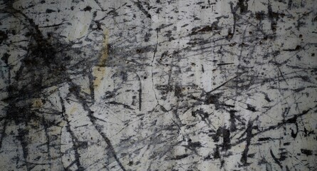 A weathered concrete wall with cracks and peeling paint, showing signs of age and decay.