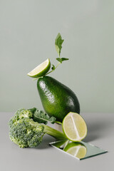 Fresh green vegetables and fruits on table. Floating food balance with broccoli, avocado, lime. Creative trendy healthy food and herbs for diet 